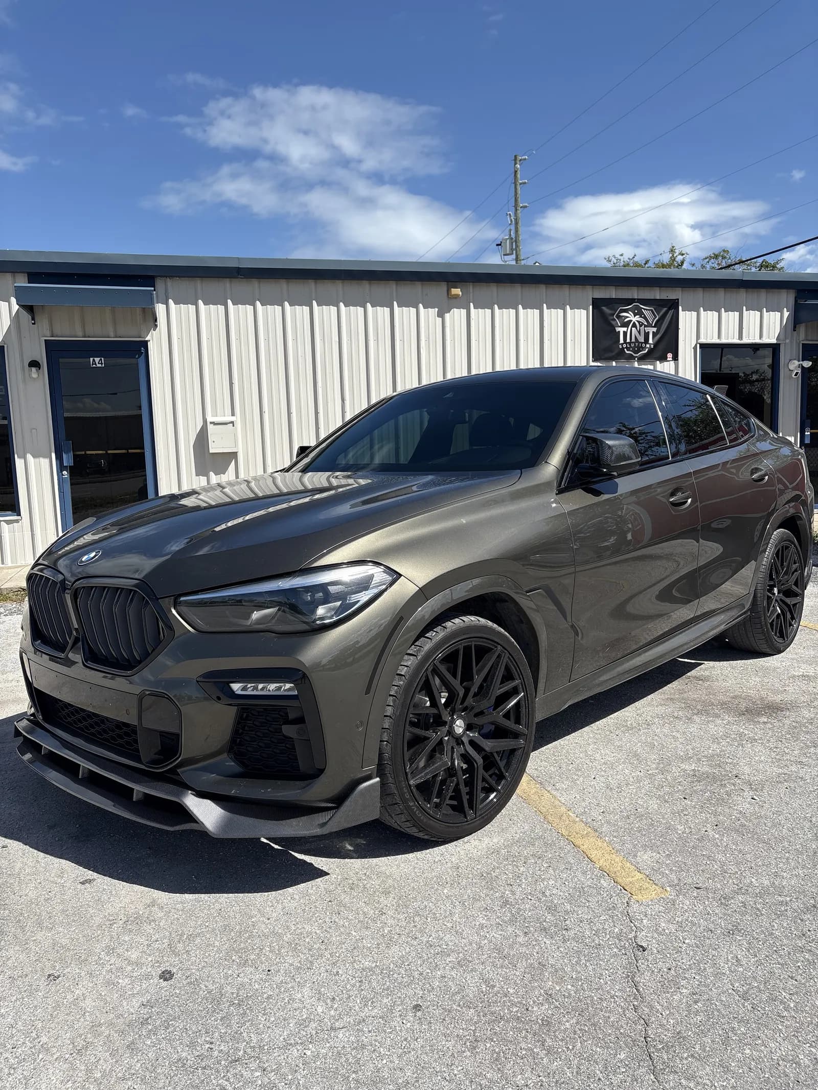 BMW X6 M outside Tint Solutions shop